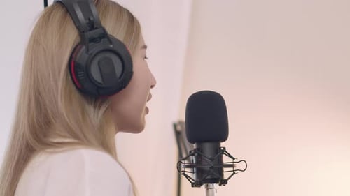 Woman Speaking Into Microphone With Headphones Close Up