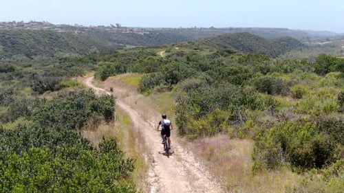 Aerial View of Riding Mountain Bike in a Small Singletrack Dry Trail in the Mountain.