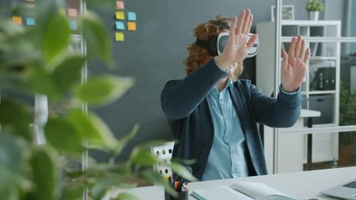 Young Man Having Fun with Ar Goggles in Office Moving Arms Entertaining Himself During Break