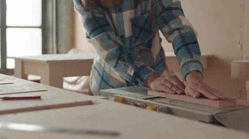 Woodworker Using Table Saw in a Workshop