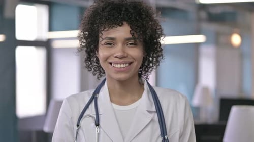 Smiling Woman Doctor with Stethoscope in Clinic