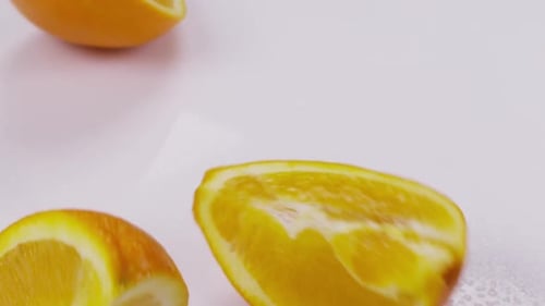 Orange Divided Into Slice on a White Background. Slow Motion.