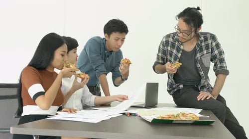 Team Eats Pizza While Collaborating in Office