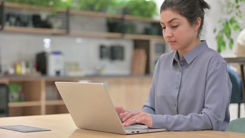 Young Woman Working at Laptop in Office