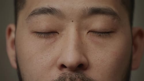 Day Dreaming or Closed Asian Man's Eyes with a Smile Winckles Close Up