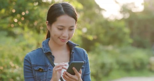 Young Woman Using Smartphone in Green Park