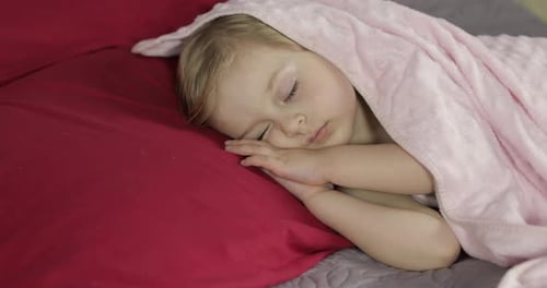 Cute Baby Sleeping on the Bed at Home. Little Girl Sleeping in Morning Light