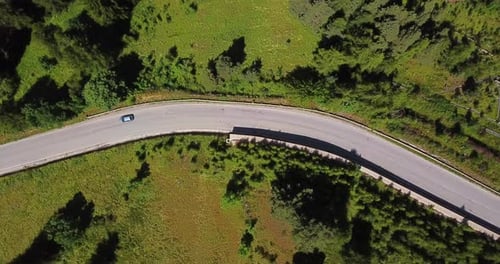 Aerial top view of car driving and traveling on an asphalt road in the middle of the nature
