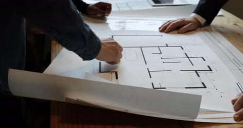 Architects Collaborate Over Blueprint in Bright Office