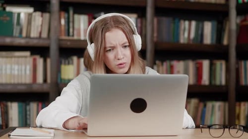 the Girl Makes the Lessons Homework on the Laptop in Modern Library the Remote Training