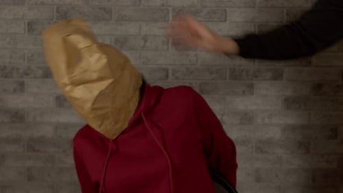 Woman with Paper Bag on Head Being Threatened