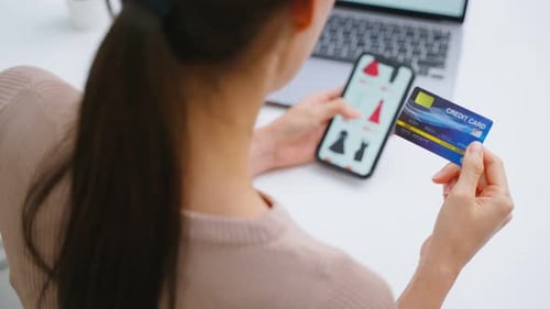 Close up of Asian young woman using mobile phone for shopping online.