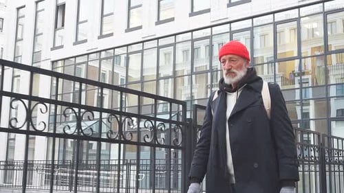 Lonely Homeless Man in Old Clothes Wanders Through Expensive Areas of the City