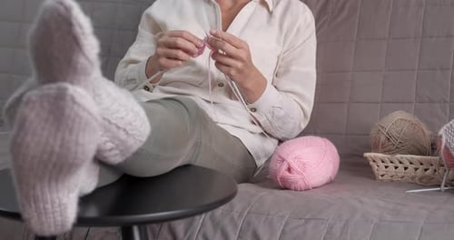 Woman Knitting at Home on the Couch