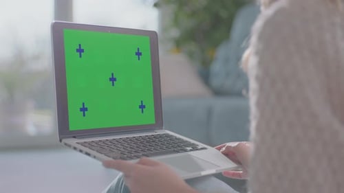 Person Using Laptop With Chroma Key Screen
