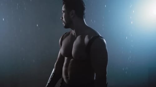 Guerrero sin camisa mirando hacia atrás bajo la lluvia