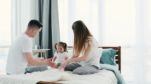 Loving Family Playing Together on Bed at Home