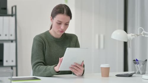 Woman Uses Tablet at Desk in Office
