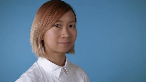 Young Adult Smiling Portrait Against a Blue Background