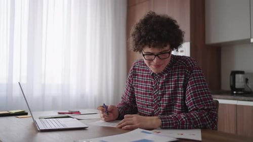 Young Adult Works from Home at Table