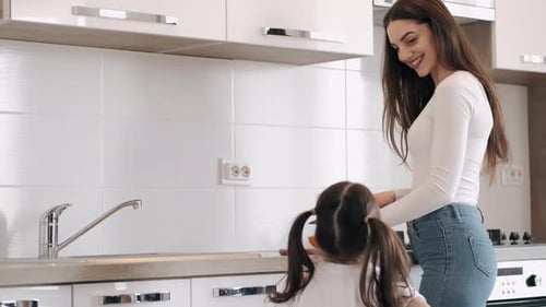 Child Giving Tulips to Smiling Woman in Kitchen