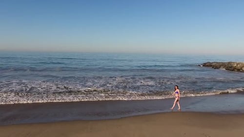 Woman Walking On The Beach