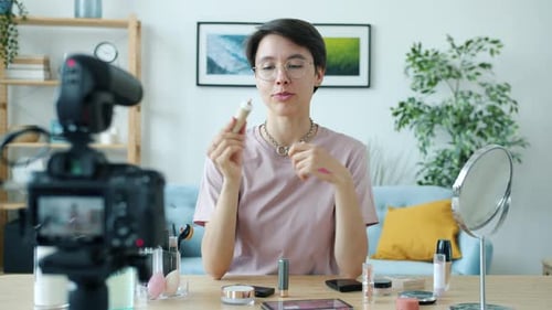 Joven alegre grabando un Vídeo sobre los productos de Visage que crea contenido para un vlog en línea