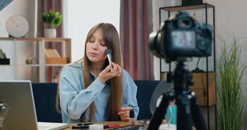 Maquilladora filmando un videoblog para su audiencia de Internet ante la cámara y mostrando cómo es correcto