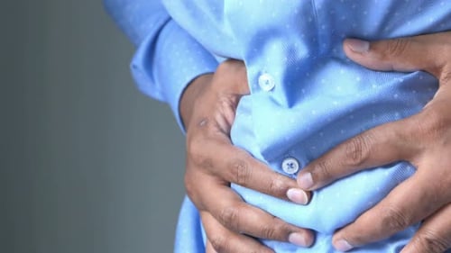 Young Man Suffering Stomach Pain Close Up.