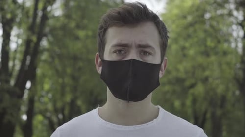 Young Adult wearing a black mask Outside
