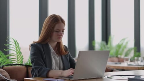 Young Woman Working on Laptop in Modern Workplace