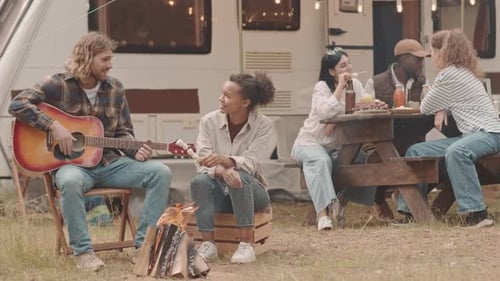 Friends Sitting by Campfire in Forest