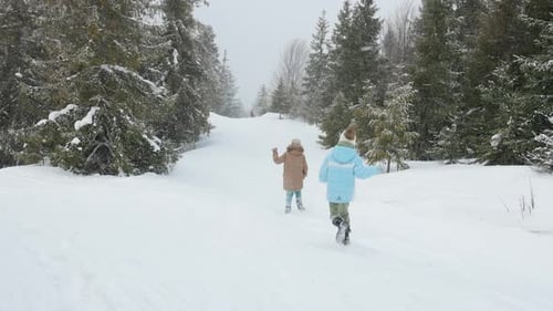 Glückliche Kinder beim Laufen im verschneiten Fichtenwald
