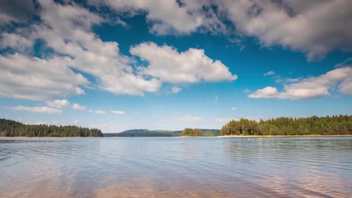 Vista matutina de un lago de montaña y nubes en movimiento