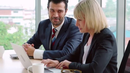 Two Business People Talk Project Strategy at Office