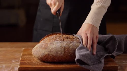 Bäckerin beim Schneiden von hausgemachtem Brot