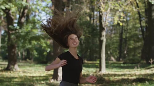 Woman Happily Throws Her Hair in a Park