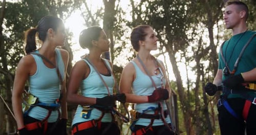 Women Listening to Man in Forest Adventure Course