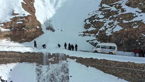 Adults clearing snow from remote mountain road