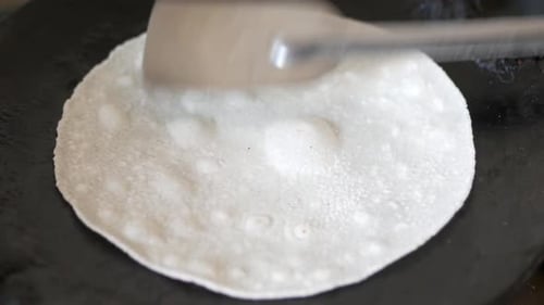 cuisson de roti chapati maison sur une poêle