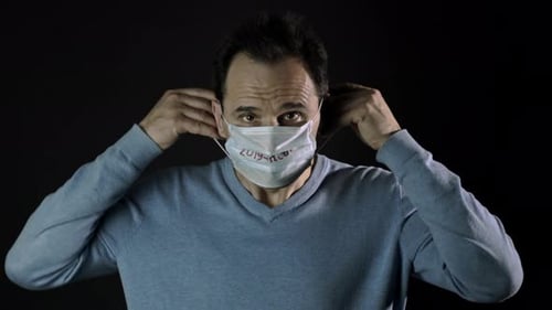 Man Puts on Mask with 2019-nCoV Text
