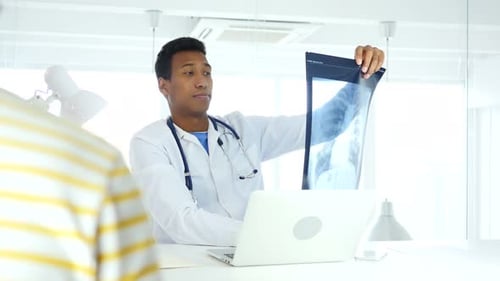Doctor Explains X-Ray to Patient in Modern Office