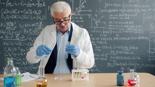 Reifer Mann Wissenschaftler führt chemische Tests im Labor durch und macht sich Notizen