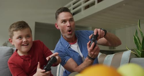 Dad and Son Play Video Games on Couch
