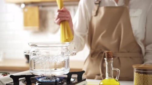 Person Cooking Pasta in a Kitchen Pot