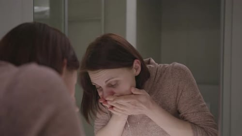 Woman Washing Her Face in Bathroom Mirror
