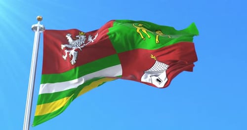 Realistic Waving Flag with Heraldic Emblems Against Blue Sky