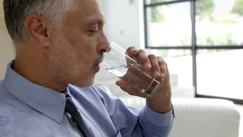 Mann trinkt Wasserglas