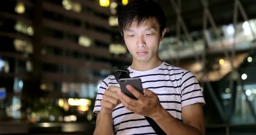 Young man use of mobile phone in the city