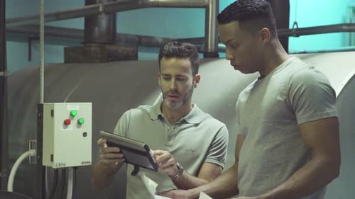 Industrial plant workers at work using digital tablet